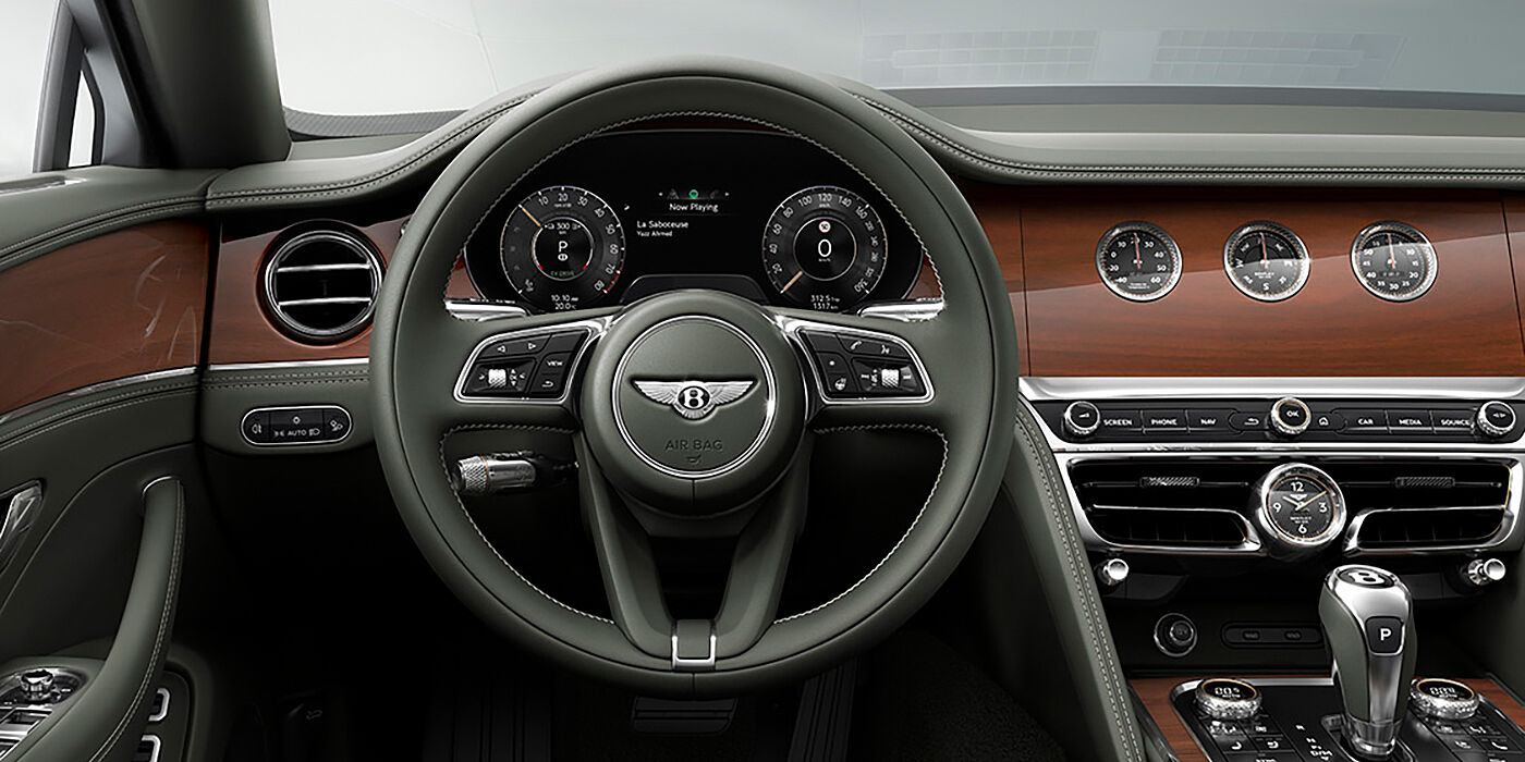 Bentley Hong Kong - Kam Lung New Bentley Flying Spur sedan front cabin in Cumbrian Green hide and Crown Cut walnut veneer showing steering wheel and Rotating Display with three clocks on face