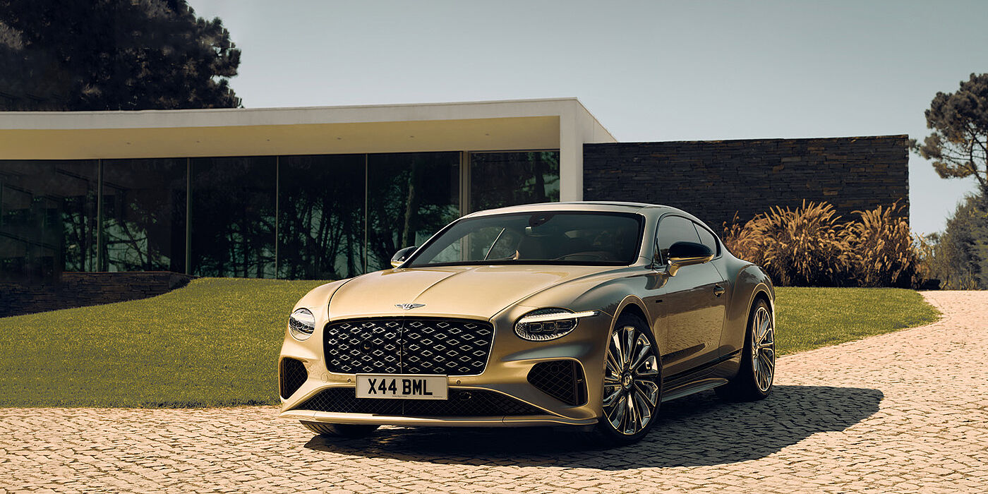 Bentley Hong Kong - Kam Lung Bentley Continental GT Mulliner coupe front three quarters in Patina paint parked outside a glass fronted building with a grass lawn behind it