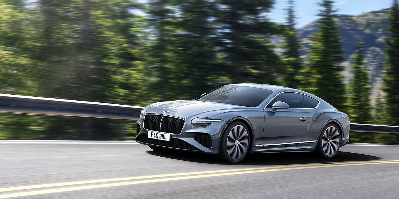 Bentley Hong Kong - Kam Lung New Bentley Continental GT coupe in Silverlake paint and 22 inch ten-spoke wheels, driving dynamically on a tree-lined road in the sunshine