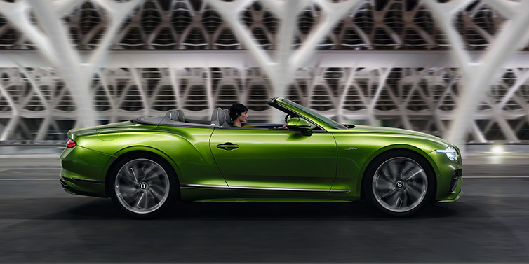 Bentley Hong Kong - Kam Lung Bentley Continental GTC Speed convertible side profile in Tourmaline Green paint driving dynamically on a bridge at night