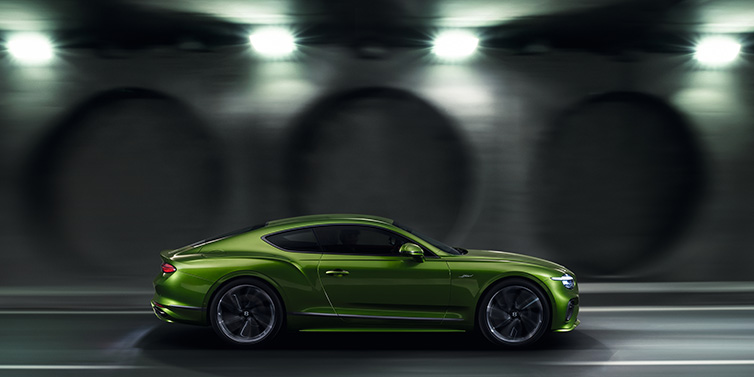 Bentley Hong Kong - Kam Lung Bentley Continental GT Speed coupe profile in Tourmaline Green driving dynamically past a concrete wall at night