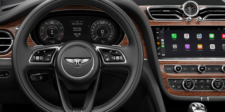 Bentley Hong Kong - Kam Lung Bentley Bentayga SUV front interior detail of steering wheel and driver screens surrounded by Beluga black hide and Crown Cut Walnut veneer