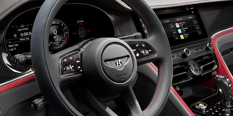 Bentley Hong Kong - Kam Lung Bentley Flying Spur Speed sedan front interior detail showing steering wheel and driver screens surrounded with Hotspur red and Gravity Grey hides